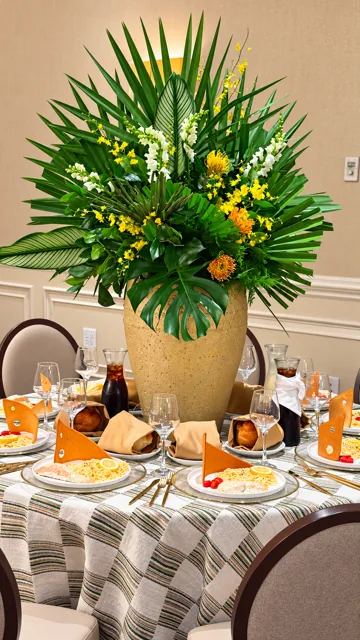 Tall floral centerpiece and gold-accented place settings