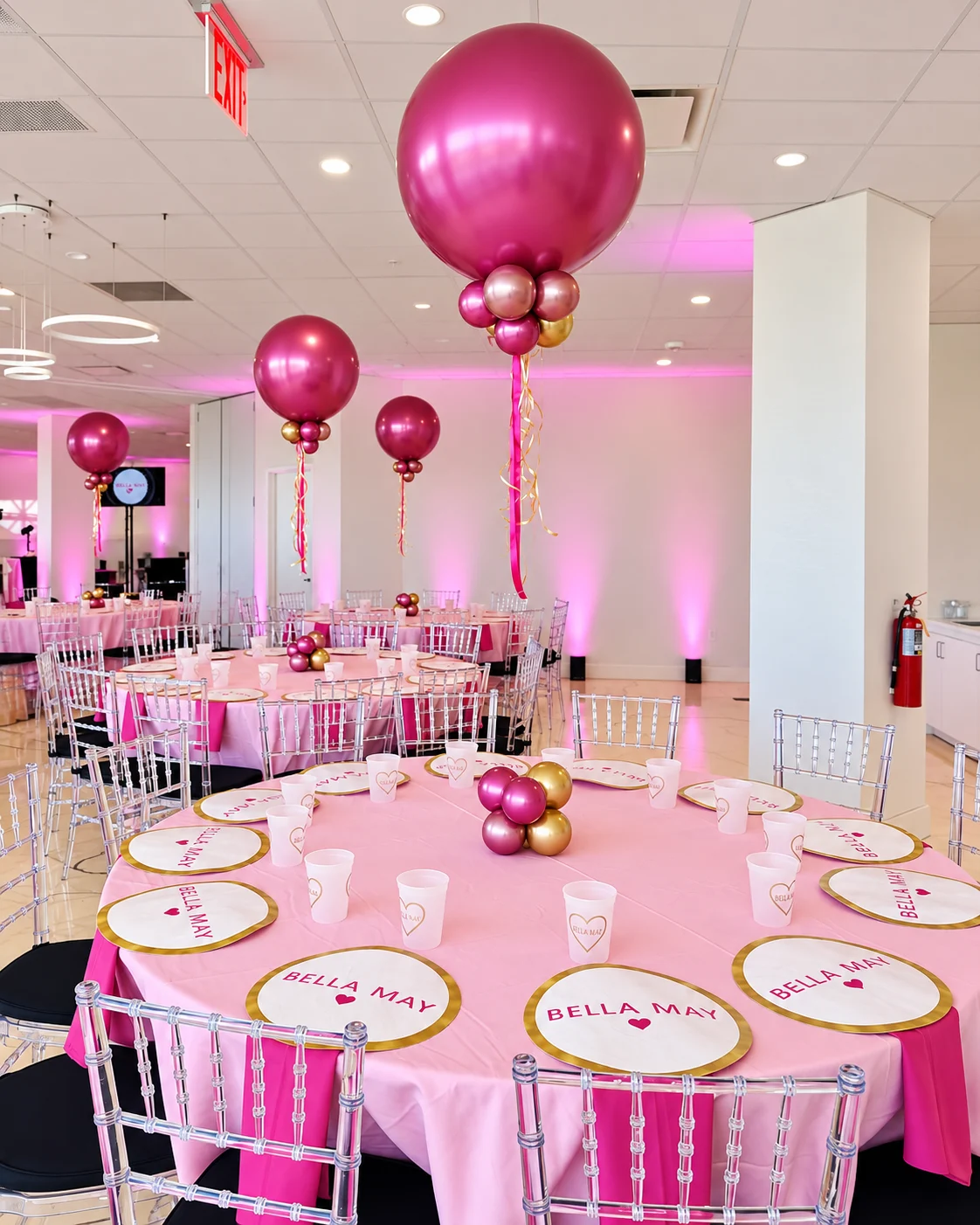 Bella May tablescape with pink linens, gold accents, and balloon centerpieces